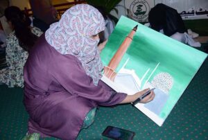 An art student participates in a painting competition that combines art and calligraphy, organized by the Punjab Arts Council Faisalabad for International Youth Day.