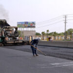 Workers with the help of modern and heavy machinery repairing the Shahdara GT Road to make the journey comfortable for commuters