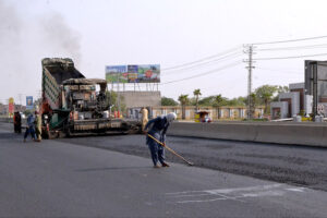 Workers with the help of modern and heavy machinery repairing the Shahdara GT Road to make the journey comfortable for commuters