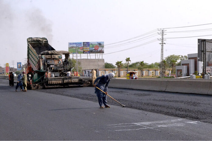 Workers with the help of modern and heavy machinery repairing the Shahdara GT Road to make the journey comfortable for commuters