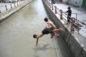 Youngsters jumping and bathing in a Canal at Gulbahar area to get some relief from scorching hot and humid weather in Provincial Capital.
