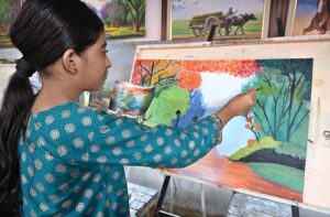 A young girl student busy in making painting at Peshawar Mor Sunday Bazaar.