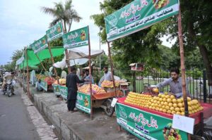 Vendors displaying fruits to attract the customers in front of Company Bagh as District Government setup Model Cart Market.