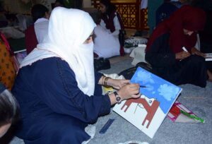An art student participates in a painting competition that combines art and calligraphy, organized by the Punjab Arts Council Faisalabad for International Youth Day.