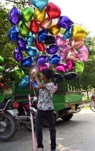 A vendor arranges handmade baskets on his bike to attract customers at a roadside in the Federal Capital