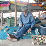 A nomadic man is making toys in his hut to earn for livelihood