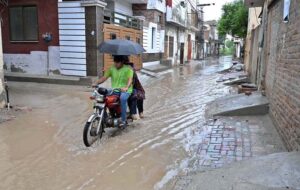 Vehicles passing through rainwater accumulated on road at College Road after heavy rain in the city.