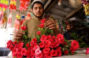 A vendor picks red roses to create bouquets at Fawara Chowk.