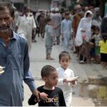 Deserving people receive free food from volunteers at Banni Chowk