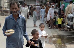Deserving people receive free food from volunteers at Banni Chowk