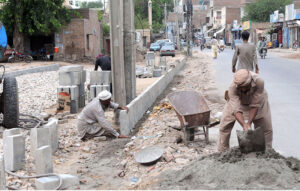 Laborers place blocks for road dividers on MDA Chowk Road, working towards a smoother and safer journey in the city Saints.