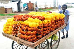 A labourer pushing hand cart loaded with bangles at Hali Road to deliver on shop in a local market.