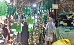 Women along with children are purchasing toys from a roadside vendor.