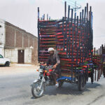 A tricycle holder on the way with heavy load of traditional beds (Charpai)