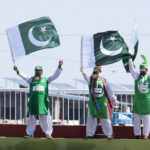 Supporters of Pakistan Cricket team wave national flags during the second day of the last cricket Test match between Pakistan and Bangladesh at Pindi Cricket Stadium