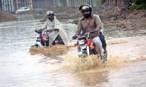 Motorcyclists battle through deep water after a drain system collapse as the torrential heavy rain break the 44-year-old record in the Provincial Capital.