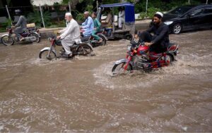 Vehicles passing through stagnant rain water accumulated at Suray Pull Chowk after heavy rain in the city