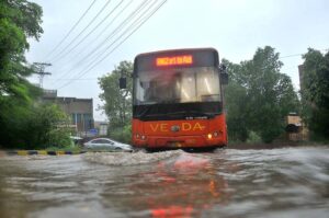 Vehicles passing through rainwater accumulated on the Kalma Chowk Road during heavy monsoon rain in the city.