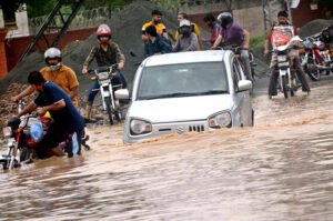 Motorcyclists battle through deep water after a drain system collapse as the torrential heavy rain break the 44-year-old record in the Provincial Capital.