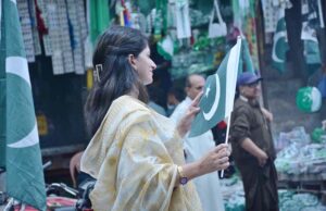 A woman is selecting national flags and other items at Aminpur Bazaar to celebrate the upcoming Independence Day in befitting manner.