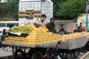 A street vendor selling decorated coconuts on a tray to attract passers-by on Jail Road in the city
