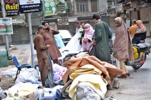 People busy in selecting and purchasing cloth from roadside vendor.