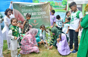 Students plants a sapling at school lawn during plantation campaign in connection with Independence Day celebrations.