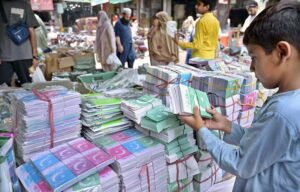 A youngster purchasing national flags and other items from vendor in a local market in connection with upcoming Independence Day celebration.
