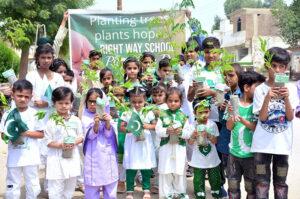 Students plants a sapling at school lawn during plantation campaign in connection with Independence Day celebrations.