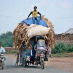 A driver rides an overloaded tricycle rickshaw, posing a risk of mishaps due to excessive weight