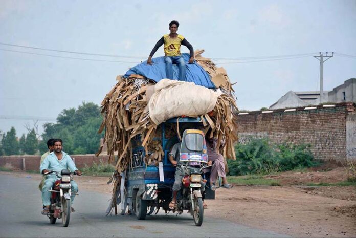 A driver rides an overloaded tricycle rickshaw, posing a risk of mishaps due to excessive weight