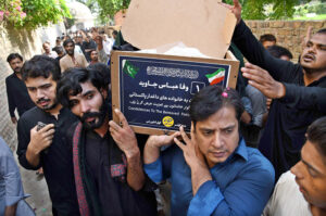 People carrying the coffin of martyrs of bus accident in Iran after offering funeral prayers at Zulfiqar Bagh.