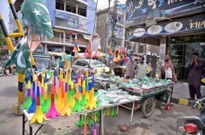 Vendor displaying national flag badges and other festive items to attract customers ahead of the upcoming Independence Day celebrations at catchahry Bzaar.