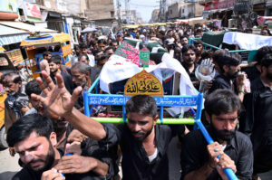 People carrying the coffin of martyrs of bus accident in Iran after offering funeral prayers at Zulfiqar Bagh.