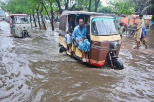 Rickshaw passing through rain water accumulated on the road after heavy rain in the city.