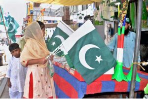 A young girl purchasing national flags from the roadside vendor in connection with upcoming Independence Day celebrations