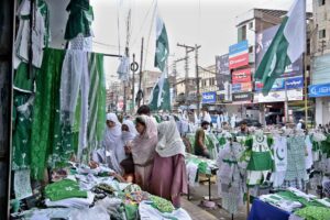Vendor displaying national flag badges and other festive items to attract customers ahead of the upcoming Independence Day celebrations at catchahry Bzaar.