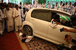 Karate players demonstrating tricks from car during Independence Day at circuit house