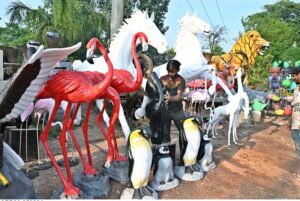 A vendor arranging and displaying replicas of birds and animals at his roadside setup to attract the customers in the Federal Capital.