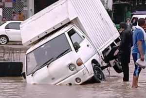 A delivery truck is stranded in a flooded road, underscoring the city's failing drain system as record-breaking rains hit the Provincial Capital.