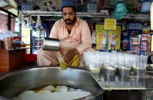 A vendor prepares traditional cold drinks, each glass of drink filled with refreshing frosts and aromas, ready to cool and delight customers at the weekly market.