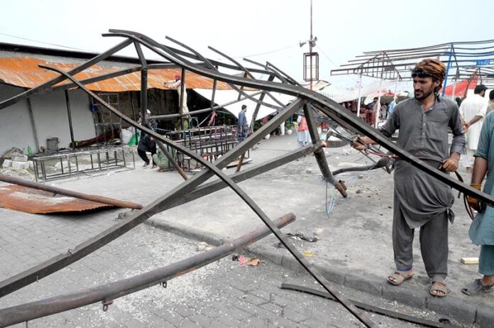 CDA workers work on restoring stalls after the fire at H-9 weekly bazaar in the Federal Capital