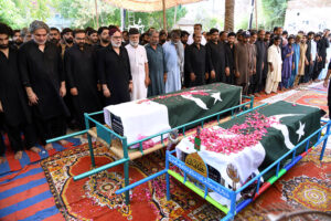People carrying the coffin of martyrs of bus accident in Iran after offering funeral prayers at Zulfiqar Bagh.