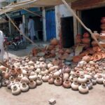 A little boy purchasing clay pot from a roadside stall in the city
