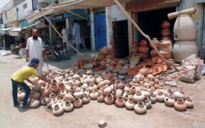 A little boy purchasing clay pot from a roadside stall in the city