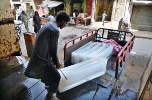 A labourer busy loading the ice block to loader vehicle at ice factory Mumtzaz colony.