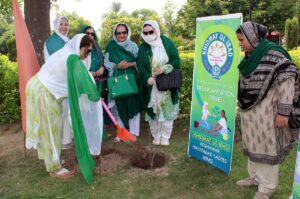 Khidmat Ul Ibad member planting a tree during a plantation drive in connection with Independence Day at Hayatabad.