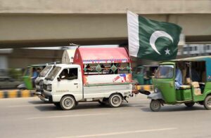 Motorists display huge national flag on the eve of Independence Day.