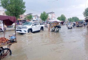 Commuters passing through flooded road as rainwater accumulated on Hussaini chowk, Mailey wali Gali and other areas after heavy rain in Bahawalpur.