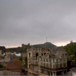 Thick clouds hover over the city, signaling an impending downpour